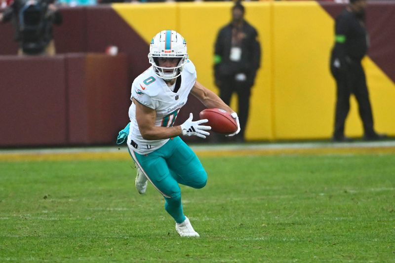 Dec 3, 2023; Landover, Maryland, USA; Miami Dolphins wide receiver Braxton Berrios (0) returns a punt against the Washington Commanders during the second half at FedExField. Mandatory Credit: Brad Mills-USA TODAY Sports