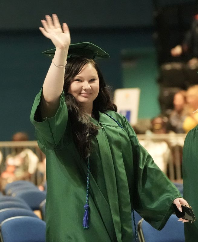 A Flagler Palm Coast High School graduating senior waves to her family at the start of commencement ceremonies, May 31, 2026, at the Ocean Center in Daytona Beach.