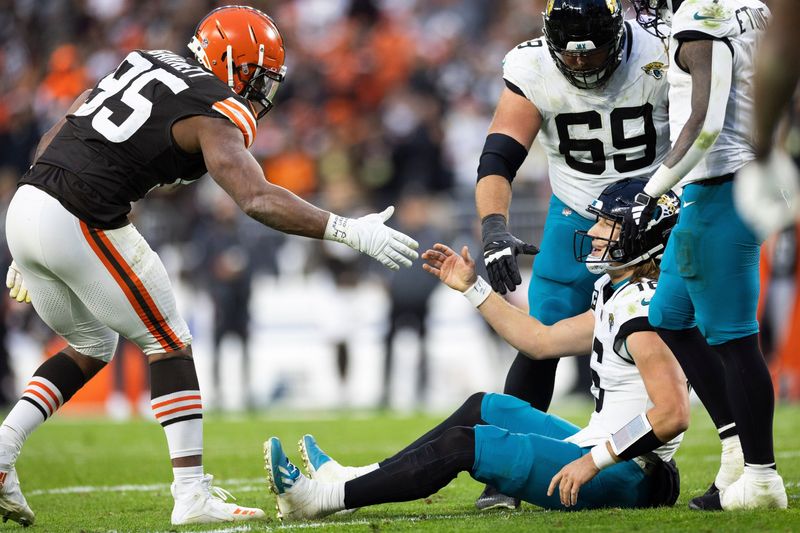 Dec 10, 2023; Cleveland, Ohio, USA; Cleveland Browns defensive end Myles Garrett (95) lends a hand to help up Jacksonville Jaguars quarterback Trevor Lawrence (16) during the fourth quarter at Cleveland Browns Stadium. Mandatory Credit: Scott Galvin-USA TODAY Sports