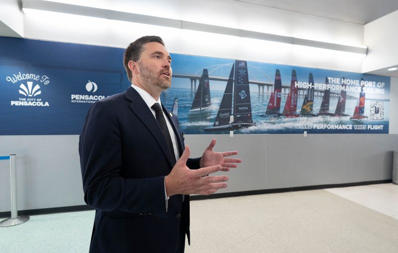 Mayor D.C Reeves speaks in front of the an American Magic mural that has been installed in the baggage claim area at Pensacola International Airport on June 2, 2026.