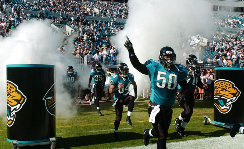 Jacksonville Jaguars linebacker Tony Gilbert (50) runs out of the tunnel with teammates during the opening ceremonies before a 2004 game against the Tennessee Titans. Gilbert, named head coach at Atlantic Coast, played for the Jaguars from 2003-07.