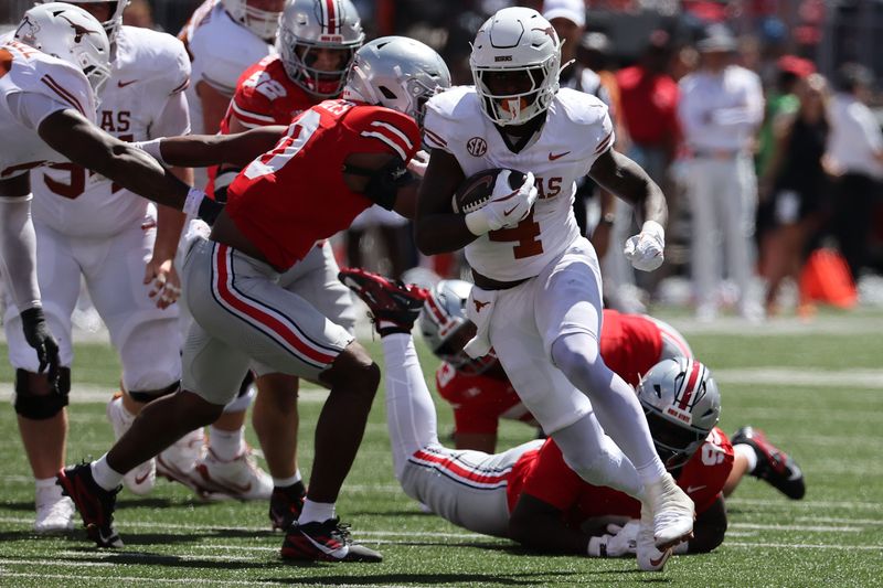 Aug 30, 2025; Columbus, Ohio, USA; Texas Longhorns running back CJ Baxter (4) rushes the ball against the Ohio State Buckeyes in the first half at Ohio Stadium. Mandatory Credit: Joseph Maiorana-Imagn Images