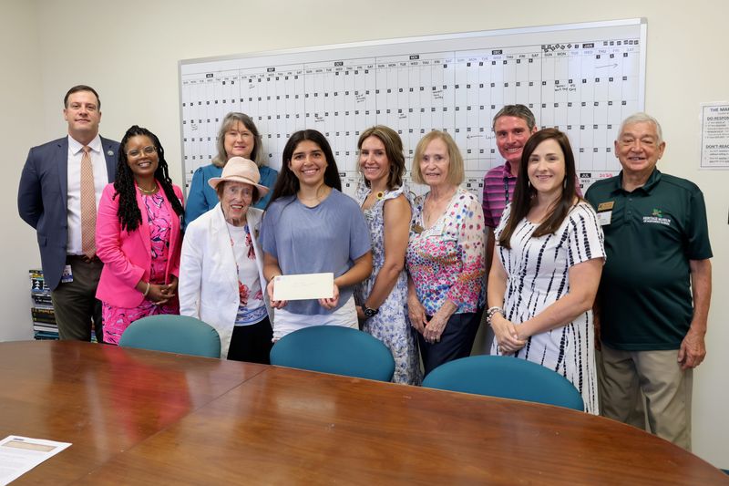 Destin Middle School's Lilly Lopez, center, who placed first in the essay contest, and her mom Principal Mandy Lopez are pictured with representatives from the Okaloosa County School District and the Heritage Museum of Northwest Florida.