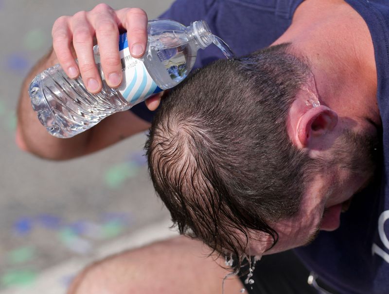 Joseph Sheryak cools off with a water bottle after completing the 2026 500 Festival Mini-Marathon on Saturday, May 2, 2026, in downtown Indianapolis.