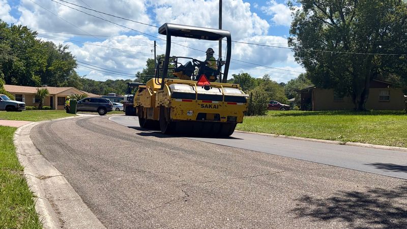 Crews put finishing touches on fresh layer of asphalt on Burgoyne Drive in Jacksonville on June 5. Mayor Donna Deegan said the city is on track to resurface 108 miles of streets in the fiscal year that goes through end of September.