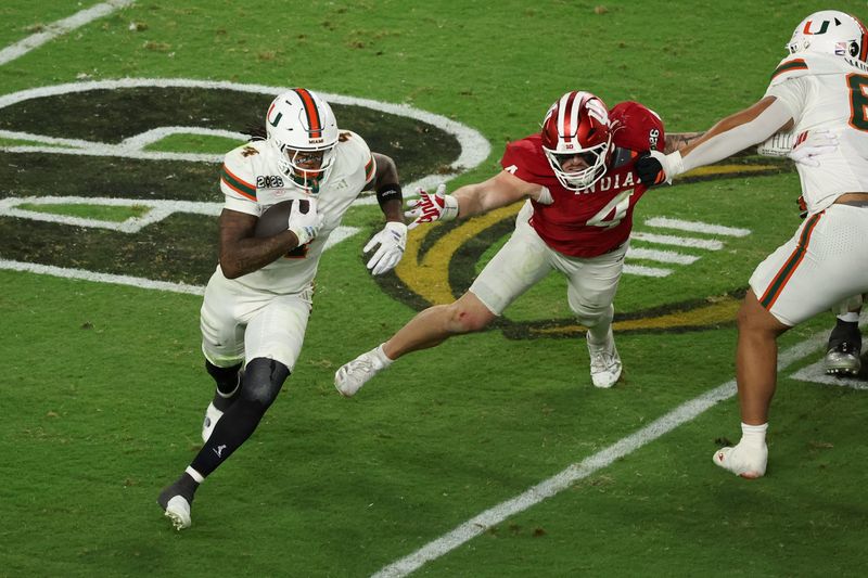 Jan 19, 2026; Miami Gardens, FL, USA; Miami Hurricanes running back Mark Fletcher Jr. (4) carries the ball defended by Indiana Hoosiers linebacker Aiden Fisher (4) in the third quarter during the College Football Playoff National Championship game at Hard Rock Stadium. Mandatory Credit: Kim Klement Neitzel-Imagn Images