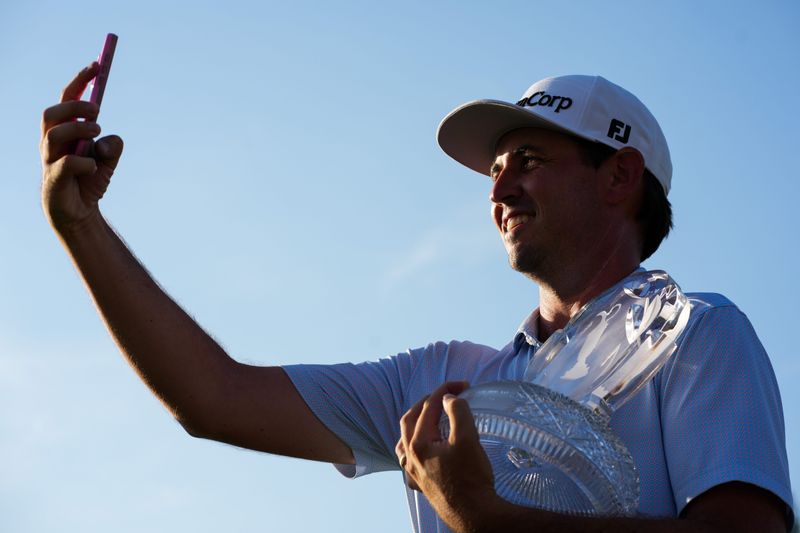 J.T. Poston takes a selfie of himself holding the championship trophy after winning The Memorial on June 7 at the Murifield Village Golf Club in Dublin, Ohio.