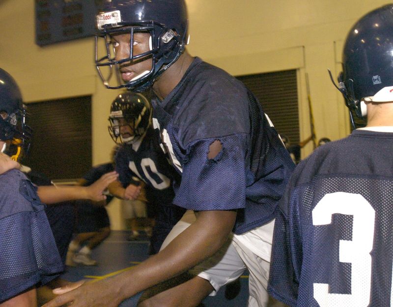 Naples High School defensive end and linebacker Spencer Adkins runs through drills during practice in the school's gymnasium due to rain on Monday, May 3, 2004.