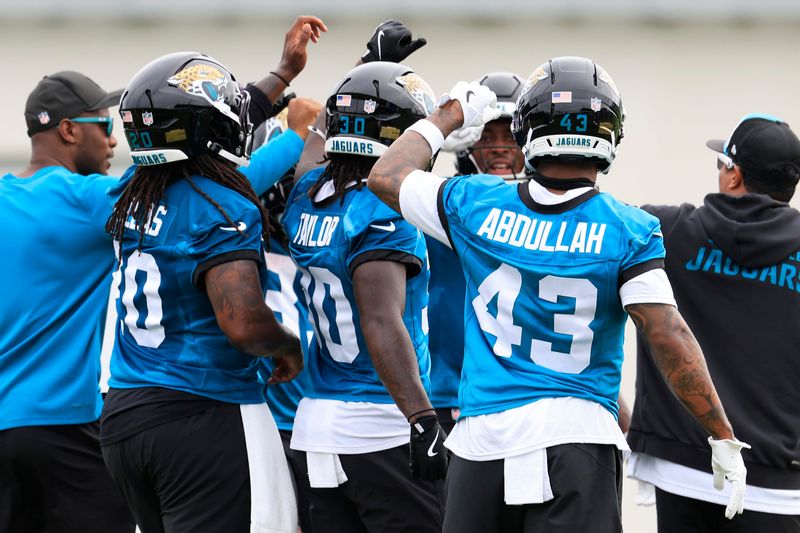 From left, Jacksonville Jaguars running back DeeJay Dallas (20), running back J'Mari Taylor (30), and running back Ameer Abdullah (43) huddle during the first day of minicamp at the Miller Electric Center, Tuesday, June 9, 2026, in Jacksonville, Fla.