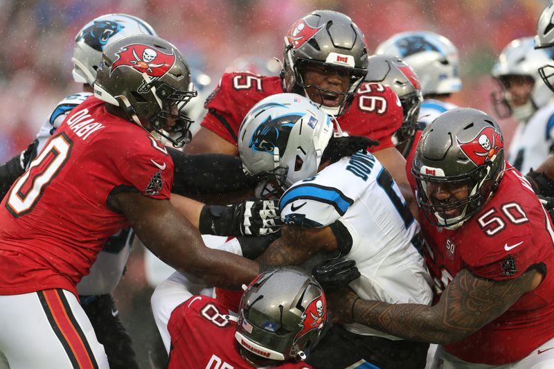 Jan 3, 2026; Tampa, Florida, USA; Tampa Bay Buccaneers linebacker Sirvocea Dennis (8) and linebacker Yaya Diaby (0) and defensive end Elijah Roberts (95) and defensive tackle Vita Vea (50) tackle Carolina Panthers running back Rico Dowdle (5) in the first half at Raymond James Stadium. Mandatory Credit: Nathan Ray Seebeck-Imagn Images