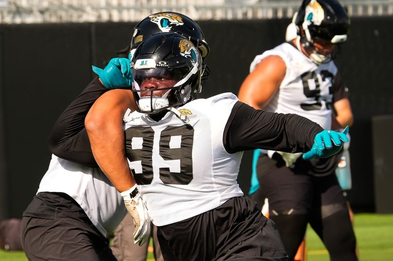 Jacksonville Jaguars defensive tackle Ruke Orhorhoro (99) runs a blocking drill with Jacksonville Jaguars defensive tackle Arik Armstead (91) during the Jaguars final Organized Team Activity on Monday, June 15, 2026 at the Miller Electric Center in Jacksonville, Fla. [Doug Engle/Florida Times-Union]