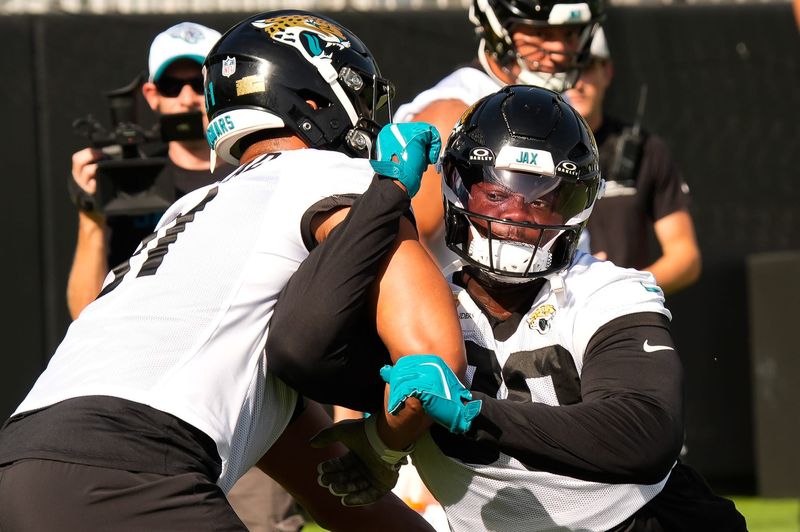 Jacksonville Jaguars defensive tackle Ruke Orhorhoro (99) runs a blocking drill with Jacksonville Jaguars defensive tackle Arik Armstead (91) during the Jaguars final Organized Team Activity on Monday, June 15, 2026 at the Miller Electric Center in Jacksonville, Fla. [Doug Engle/Florida Times-Union]