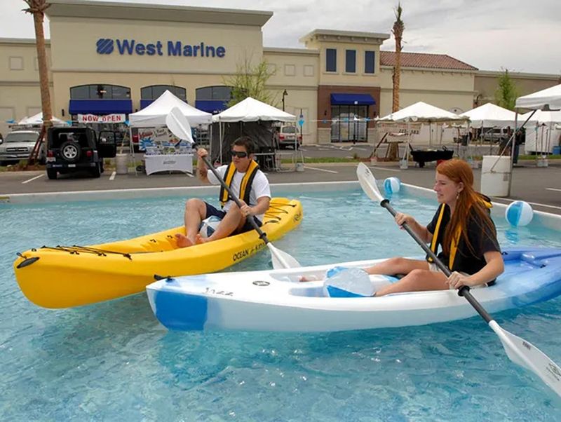 Sales associates James Corbett and Amanda Weed paddle kayaks in a temporary pool at the West Marine Superstore in 2009.