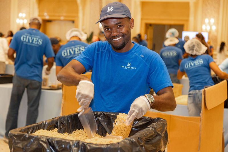 Kemor Watson an employee of The Breakers, scoops pasta during the Day of 100,000 Meals collaborative initiative with the Palm Beach County Food Bank on May 27.