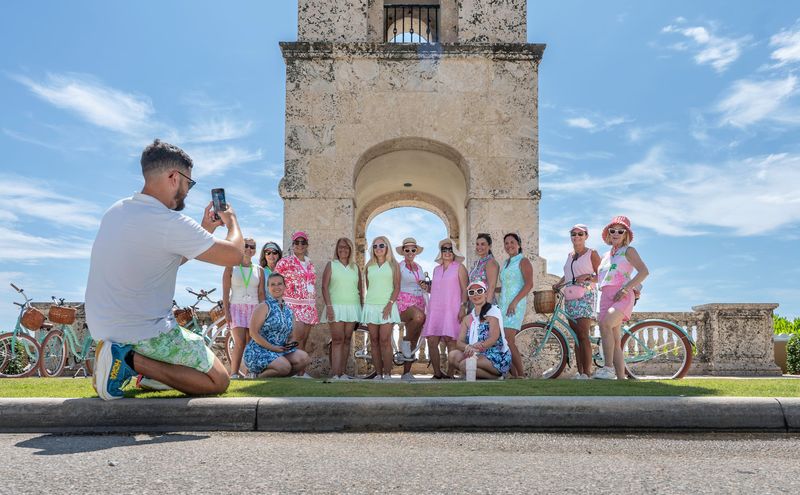 During a brief break in a guided 1-hour scenic bike tour through Palm Beach with Palm Beach EBike Rentals, a group of 2026 Pink Retreat participants pose for a photo at the Palm Beach Clock Tower on June 12.