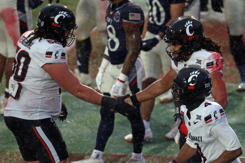 Jan 2, 2026; Memphis, TN, USA; Cincinnati Bearcats quarterback Samaj Jones (5) reacts with offensive lineman Evan Tengesdahl (50) after a touchdown run during the second quarter against the Navy Midshipmen at Simmons Bank Liberty Stadium. Mandatory Credit: Petre Thomas-Imagn Images