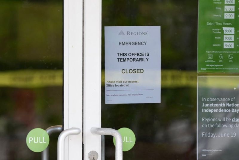 A sign is posted on the door of a Regions Bank located on North Monroe stating “ emergency this office is temporarily closed”