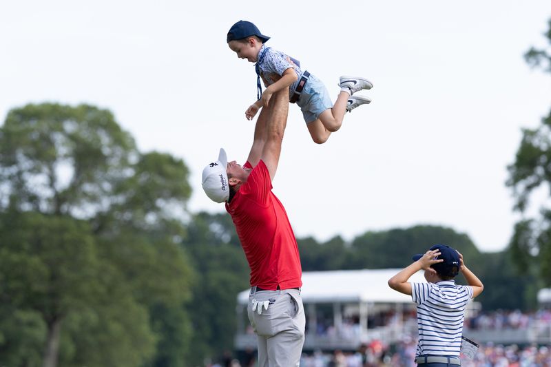 Keegan Bradley celebrates with his sons Cooper and Logan after winning the 2025 Travelers Championship golf tournament in Cromwell, Connecticut.
