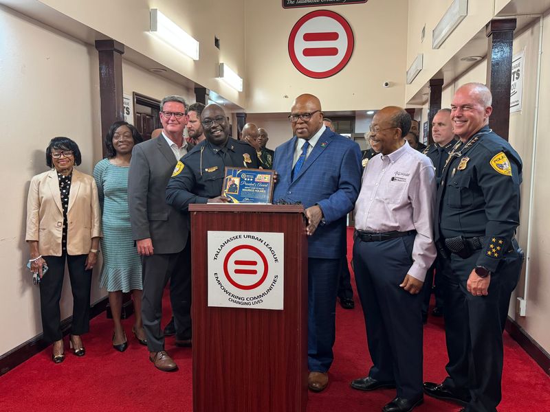 City and county commissioners join President and CEO of the Tallahassee Urban League, Curtis Taylor, as he presents an award to retiring Tallahassee Police Department Deputy Chief Maurice Holmes. The award was accompanied by a press conference addressing gun violence.