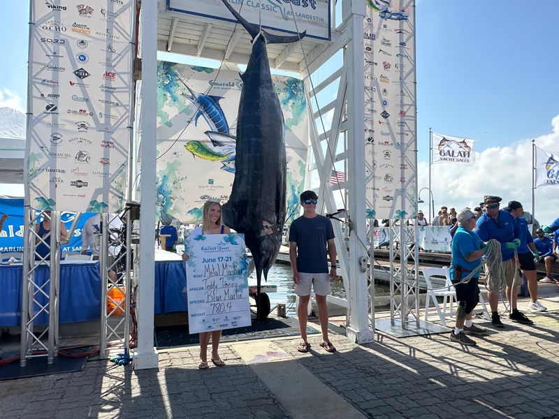 Teddy Tinney, 17, of Alabama landed a 780.4-pound blue marlin while fishing aboard the Metal Masher with Capt. Landon Bell out of Orange Beach, Alabama to take first place in the 24th annual Emerald Coast Blue Marlin Classic on June 22. Also pictured is Miss Destin 2026 Kaylynn Hayles.