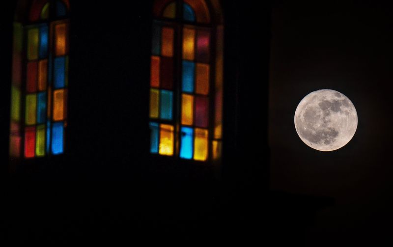 With the stained-glass steeple base from Club Zion, a church in Cocoa Beach, Florida, in the foreground, the Strawberry Moon rose over the ocean.