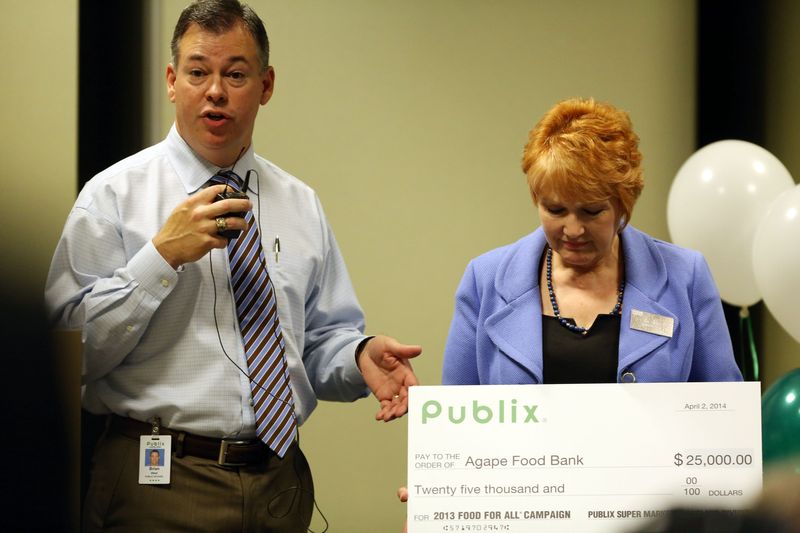 Brian West presents Agape Food Bank director Kim Long a check during a luncheon in 2014 to honor nonprofits that provide food to the needy.
