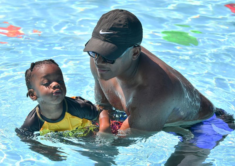 Westin Casey, 2, swims with his dad, Widly, at the World's Largest Swimming Lesson event. Westin has already accomplished swimming underwater.