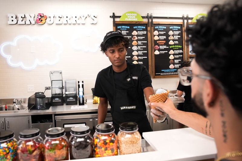 Jeremiah Renaldo hands an ice cream cone to customer Angel Garcia at Ben & Jerry’s soft opening Thursday June 25, 2026 at 1027 Park St, Jacksonville, FL. Their grand opening is July 4th, 2026. [Doug Engle/Florida Times-Union]