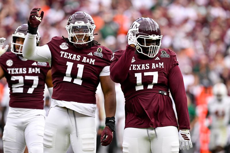 Dec 20, 2025; College Station, TX, USA; Texas A&M Aggies defensive tackle Albert Regis (17) and defensive tackle Tyler Onyedim (11) celebrate during the game between the Aggies and the Hurricanes at Kyle Field. Mandatory Credit: Jerome Miron-Imagn Images