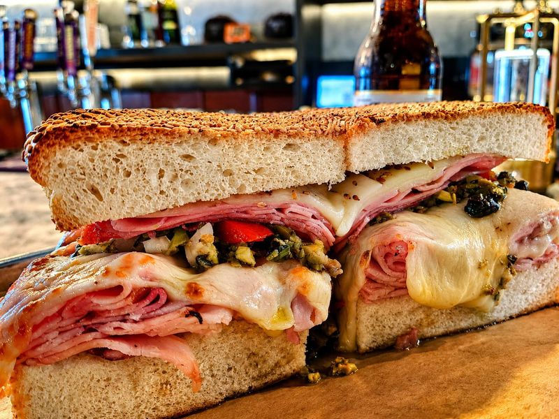 The popular muffuletta at Sarasota restaurant Lucky 8 layers Italian meats, melted cheese and olive salad on sesame bread inspired by the classic New Orleans sandwich. Photo taken June 16, 2026.