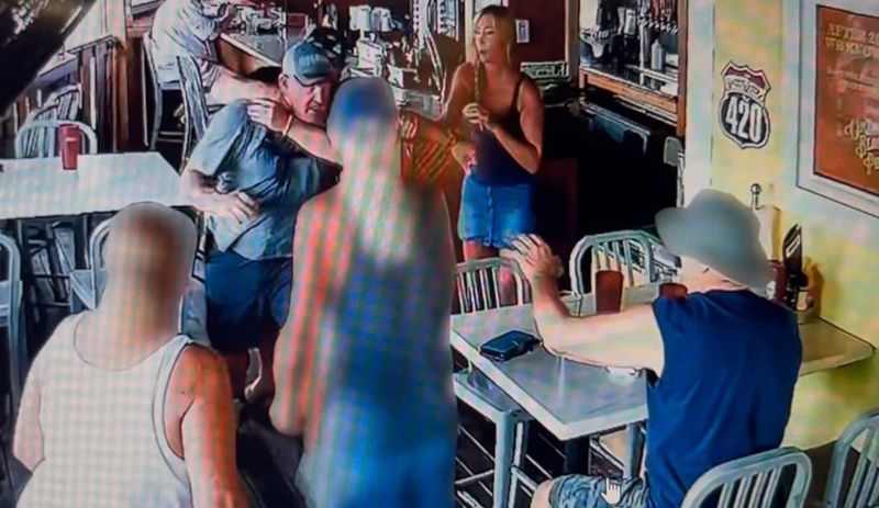 Volusia Sheriff's Office Sgt. Jason Stickels is grabbed from behind and taken down after Stickels battered a couple at Merk's Bar & Grill in New Smyrna Beach on July 6, 2026, according to the Volusia Sheriff's Office. Stickels, who was off-duty, was arrested.