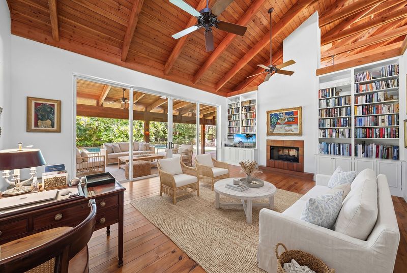 Seen in a photo that has been digitally "staged" with furniture, the library is crowned by a slanted wood-plank ceiling and has a gas fireplace.