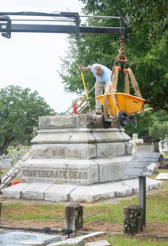Jamie Glynn, of Gulf Coast Monuments, works on reassembling the Confederate monument at the historic St. John’s cemetery in Pensacola on July 13, 2026. The monument’s new location is at the grave of former Florida governor and Confederate general Edward A. Perry.