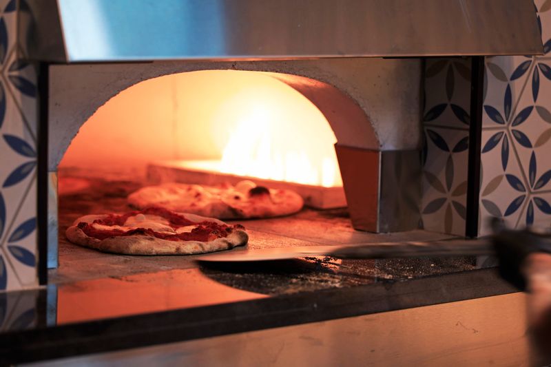 An Earthtone wood-fired oven is the centerpiece of the open kitchen at the new Alder & Oak Jacksonville Beach.