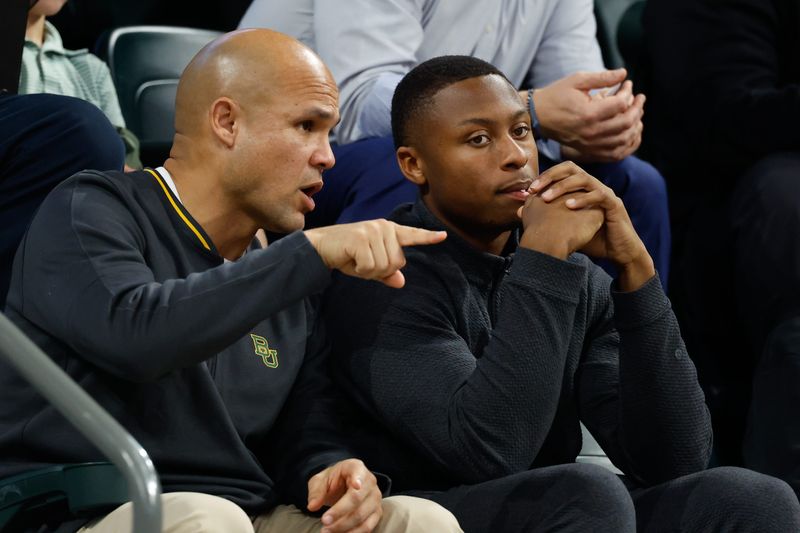 Jan 7, 2026; Waco, Texas, USA;  DJ Lagway, a Florida quarterback currently in the transfer portal, sits with Baylor Bears football head coach Dave Aranda, left, during the first half of a game between the Baylor Bears and Iowa State Cyclones at Paul and Alejandra Foster Pavilion. Mandatory Credit: Chris Jones-Imagn Images