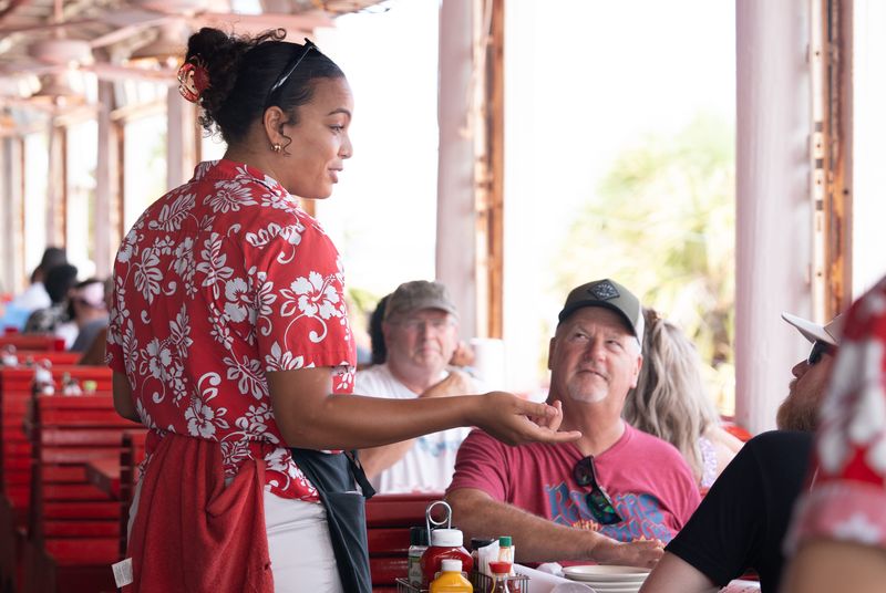 Server Tylah Yeomans, left, chats with guests at Crabs on the Beach in Pensacola Beach on July 15, 2026.