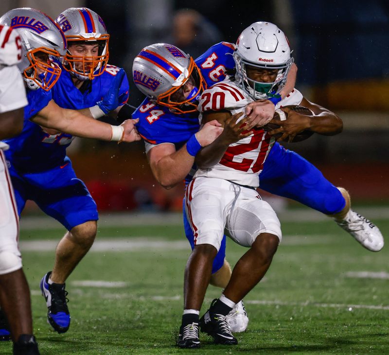 Bolles Bulldogs defensive lineman Asher Ghioto (34) brings down Cardinal Gibbons running back Jeremy Douglas (20) in the second quarter in the FHSAA Class 2A high school football semifinal at Bolles School in Jacksonville, Fla. Friday December 5, 2025. The winner advances to the state final in Miami. Bolles won 42-20. [Doug Engle/Florida Times-Union]
