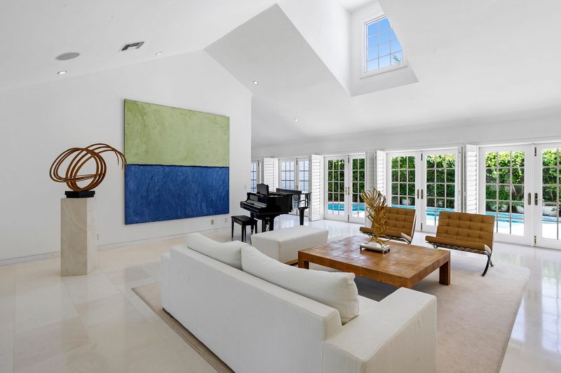 Completely rebuilt, a three-bedroom house at 222 Monterey Road in Palm Beach has vaulted ceilings and contemporary style interiors, as the poolside living room shows. The North End property is listed at $10.9 million.