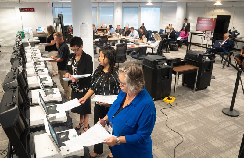 Staff members of the Lee County Supervisor of Elections office feed test ballots into election day tabulators during a logic and accuracy testing process at the Lee County Supervisor of Elections Office in Fort Myers on Wednesday, July 22, 2026.