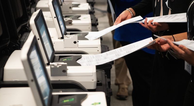 Staff members of the Lee County Supervisor of Elections office feed test ballots into election day tabulators during a logic and accuracy testing process at the Lee County Supervisor of Elections Office in Fort Myers on Wednesday, July 22, 2026.