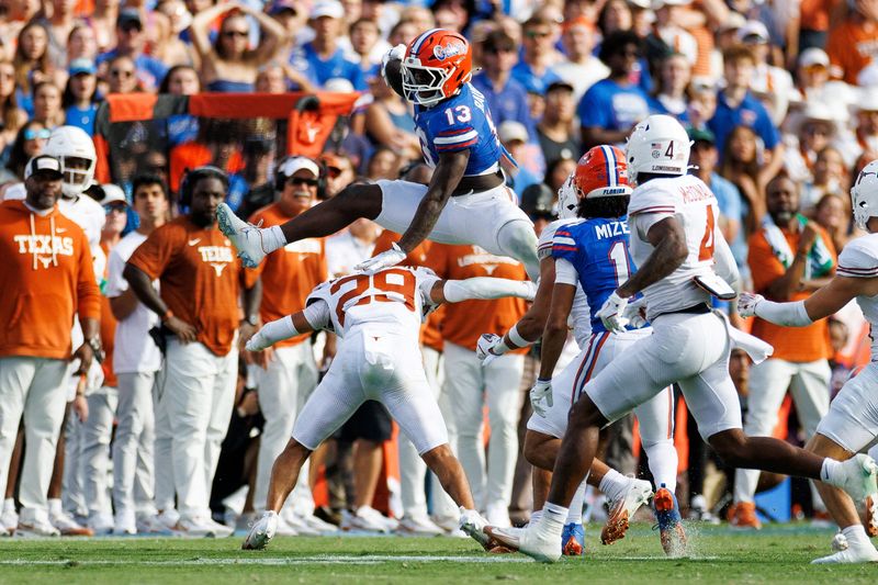 Oct 4, 2025; Gainesville, Florida, USA; Florida Gators running back Jadan Baugh (13) leaps over Texas Longhorns defensive back Graceson Littleton (29) during the first half at Ben Hill Griffin Stadium. Mandatory Credit: Matt Pendleton-Imagn Images     TPX IMAGES OF THE DAY