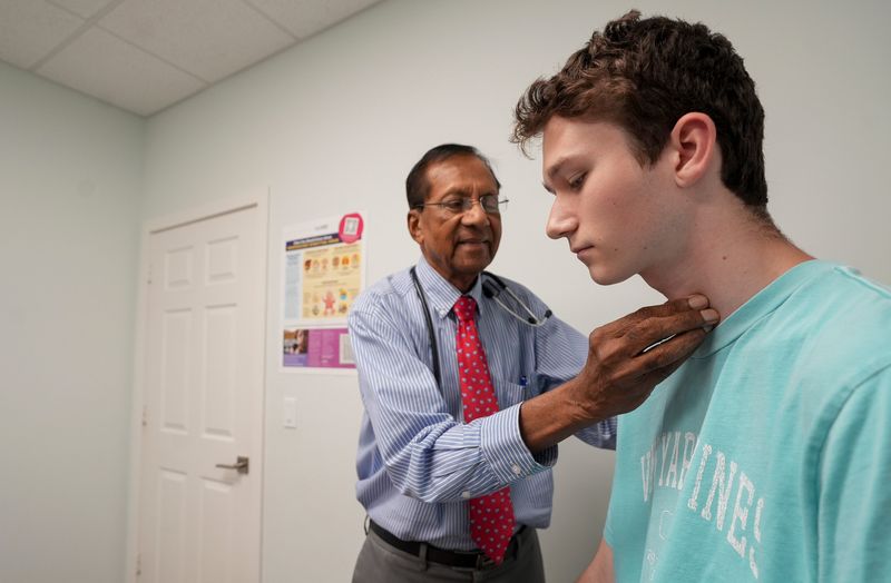 Dr. Asoka Wijetilleke sees Luke McGuigan, 18, for a final check up, July 27, 2026, at Vero Beach Pediatrics. Dr. Wije has seen McGuigan since he was born, with the same care he has had with countless generations of children in Vero Beach for the last five decades. Dr. Wije retires Aug. 4 after 50 years of service to the community.