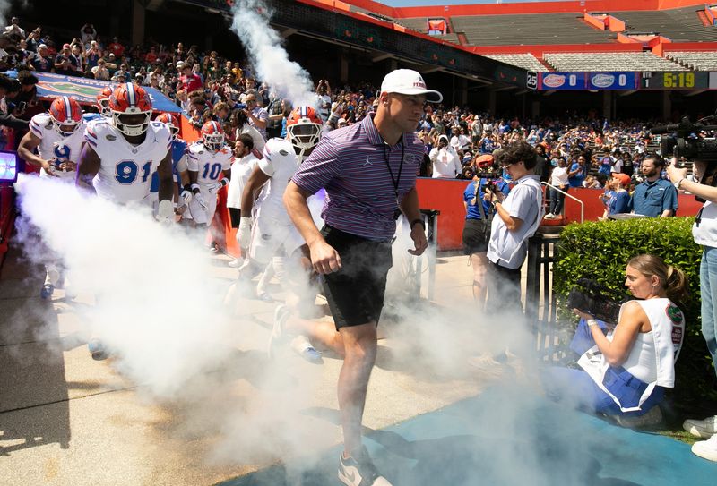 Florida head coach Jon Sumrall and the team blasts out onto the field before the Orange and Blue game at Steve Spurrier Field at Ben Hill Griffin Stadium in Gainesville, FL on Saturday, April 11, 2026. [Alan Youngblood/Gainesville Sun]