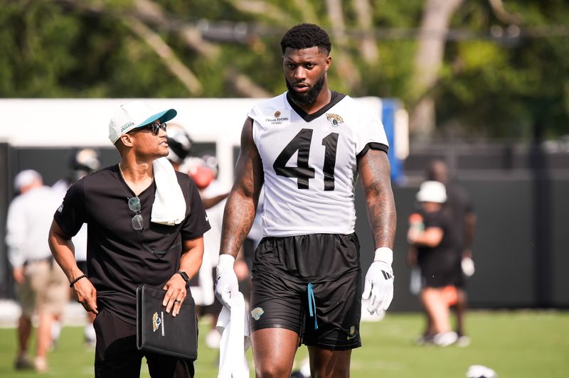 Dylan Morton Senior Director of Football Communications; for the Jacksonville Jaguars, left, talks with Jacksonville Jaguars Defensive End Josh Hines-Allen (41) after the second day of NFL Training Camp at the Miller Electric Center on Thursday, July 30, 2026, in Jacksonville, Fla. [Doug Engle/Florida Times-Union]
