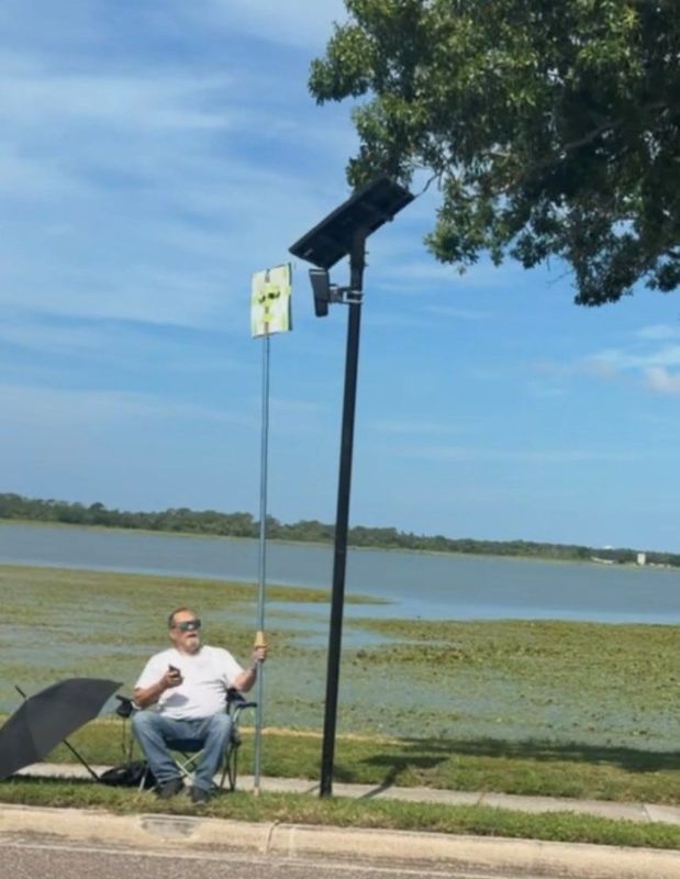 Carl Gunn, 77, of St. Petersburg protests a surveillance camera near his home, using a 10-foot pool skimmer pool.