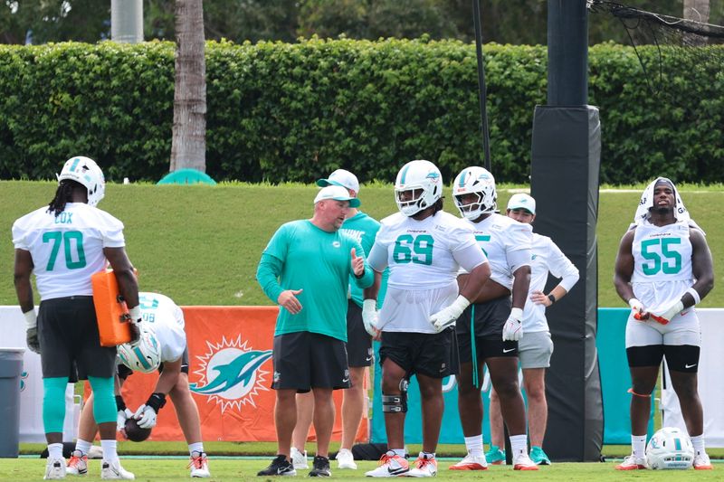 Jul 31, 2026; Miami Gardens, FL, USA; Miami Dolphins offensive line coach Zach Yenser speaks to  guard Jamaree Salyer (69) during practice at Baptist Health Training Complex. Mandatory Credit: Sam Navarro-Imagn Images