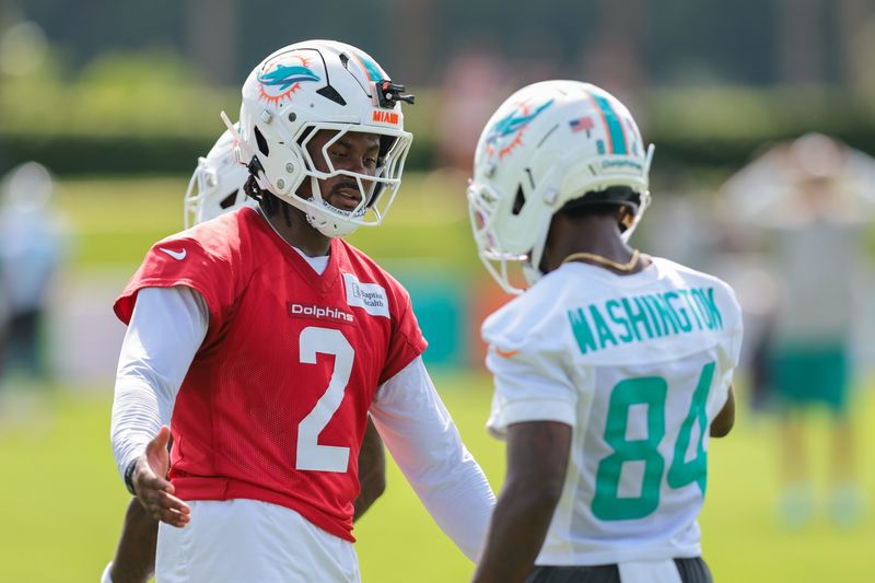 Jul 30, 2026; Miami Gardens, FL, USA; Miami Dolphins quarterback Malik Willis (2) shakes hands with wide receiver Tahj Washington (84) during practice at Baptist Health Training Complex. Mandatory Credit: Sam Navarro-Imagn Images