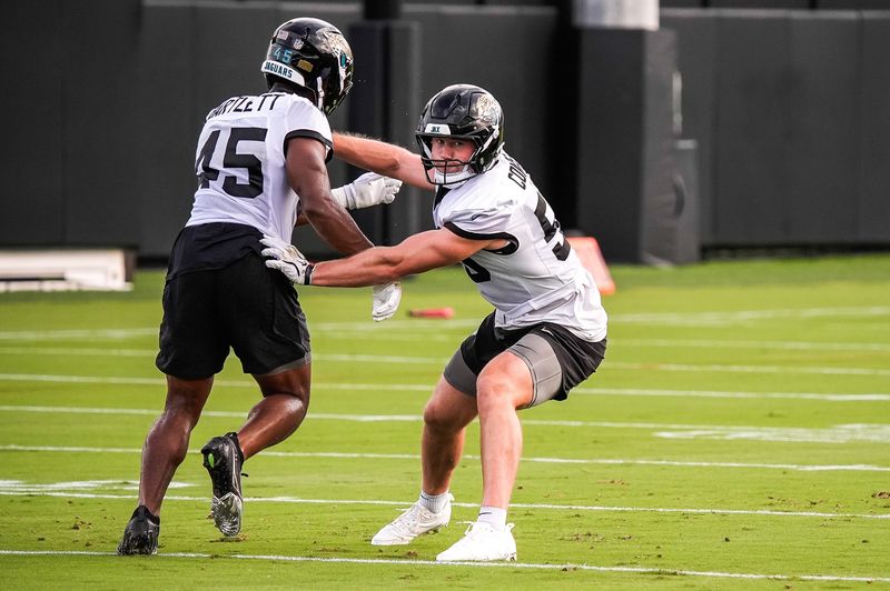 Jaguars linebacker Branson Combs (50, right) runs a drill with teammate Jared Bartlett on Aug. 2.