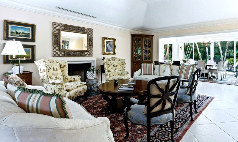 The living area flows into the sunroom, where glass doors open to the backyard and pool area.