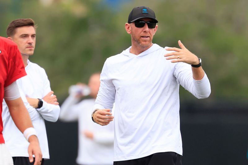 Jacksonville Jaguars head coach Liam Coen, center, directs practice next to general manager James Gladstone  during the sixth day of NFL training camp at the Miller Electric Center on Tuesday, Aug. 4, 2026, in Jacksonville, Fla.